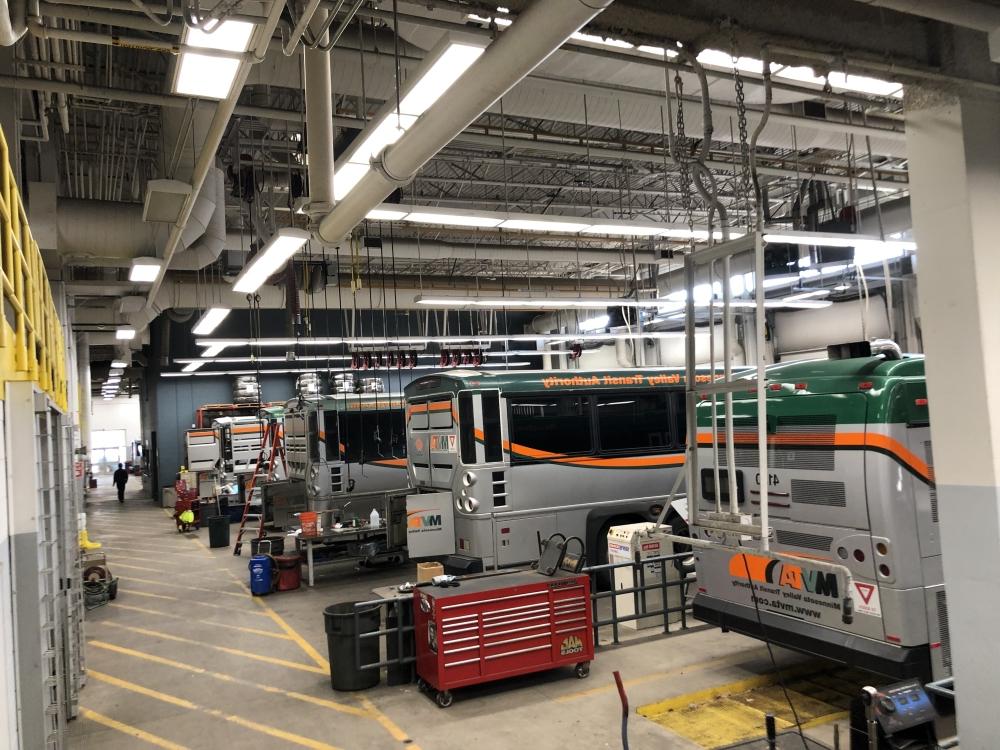 Garage with busses and overhead LED lighting